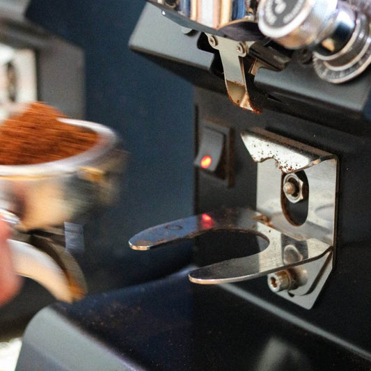 Barista trainee adjusting grind size and brew ratio as part of Harvester Coffee Academy training